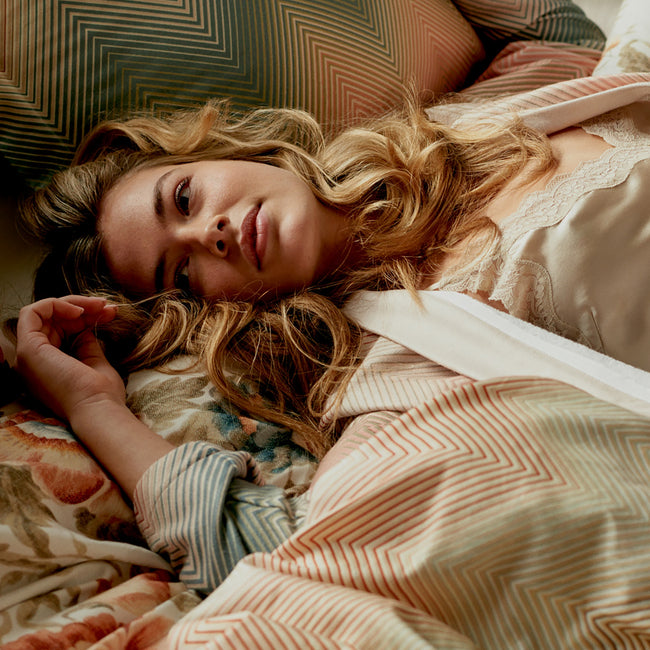 ROMANCE dekbedovertrekset | cream tan Vrouw liggend op bed met een badjas aan en op een dekbedovertrek met een zig zag print