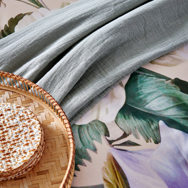 HOLIDAY dekbedovertrekset | cream tan detail shot van een bed met een lichtblauw plaid en een ontbijt op bed