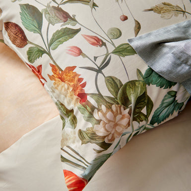 HOLIDAY dekbedovertrekset | cream tan Detail shot van een kussensloop met prachtige bloemen en planten op een beige achtergrond