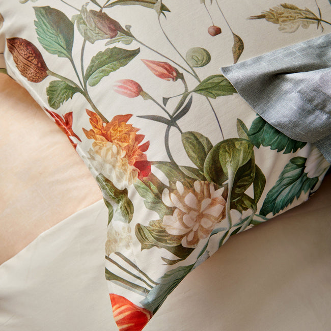 HOLIDAY dekbedovertrekset | cream tan Detail shot van een kussensloop met prachtige bloemen en planten op een beige achtergrond