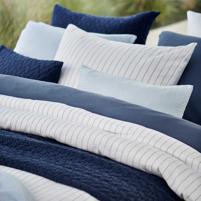 PURE 90 dekbedovertrekset | white Pure 90 white dekbedovertrek heeft blauwe strepen op een witte achtergrond, gemaakt van een combinatie van katoen en linnen. De achterkant van het dekbedovertrek is wit, gemaakt van katoensatijn. De kussens hebben aan de voorkant kant de strepen en aan de andere kant is het effen wit.