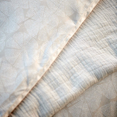 PURE 93 XL dekbedovertrekset | stone Pure 93 linen dekbedovertrek heeft een patroon met cirkels die uit partjes bestaan en gevormd worden door kleine witte stipjes op een beige achtergrond. De achterkant van het dekbedovertrek heeft hetzelfde patroon. De kussens hebben ook aan allebei de kanten hetzelfde patroon.