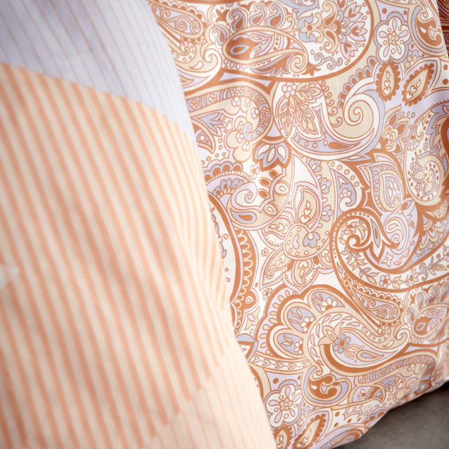 HAPPY FEVER dekbedovertrekset | apricot blush detail shot van een dekbedovertrek in een paisley print in paarse en oranje kleuren