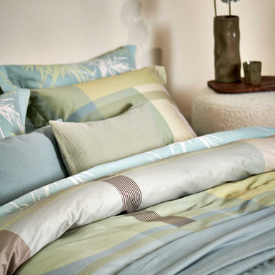 PALM PARADISE dekbedovertrekset | thyme Palm Paradise thyme dekbedovertrek heeft silhouetten van palmbomen in bruin, beige, groen en wit op een lichtblauwe achtergrond. De achterkant van het dekbedovertrek heeft dezelfde print. De kussens hebben aan beide kanten palmbomen.