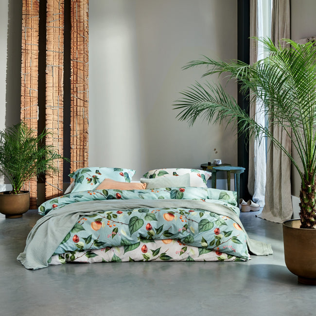 FRUIT GARDEN dekbedovertrekset | cream tan bed met een dekbedovertrek met vruchten, bladeren en vlinders in een groene en beige kleur in een rustige setting