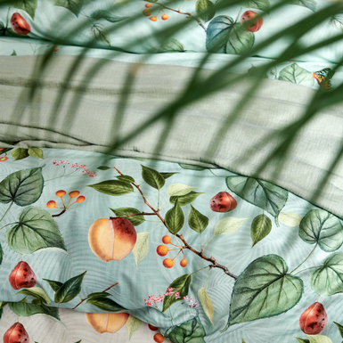 FRUIT GARDEN dekbedovertrekset | cream tan detail shot van een dekbedovertrek in een groene en beige kleur met vruchten, balderen en vlinders