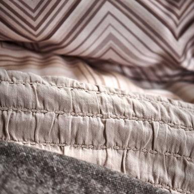 DYNAMIZE dekbedovertrekset | taupe Detail shot van dekbedovertrek en plaids in aarde en bruin tinten