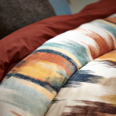 TRIBAL dekbedovertrekset | multi detail shot van een dekbedovertrek met een print in oranje en blauwe kleuren een dekbedovertrek in een roest bruine/oranje kleur