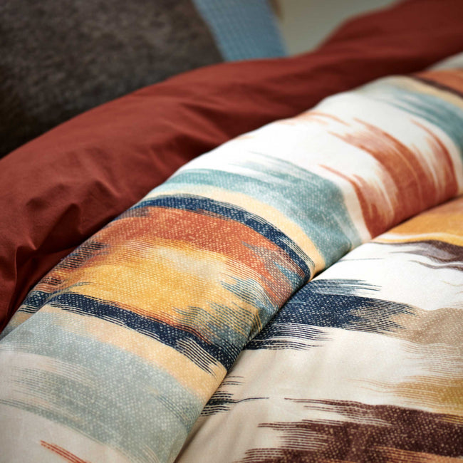 TRIBAL dekbedovertrekset | multi detail shot van een dekbedovertrek met een print in oranje en blauwe kleuren een dekbedovertrek in een roest bruine/oranje kleur