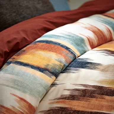 TRIBAL XL dekbedovertrekset | multi detail shot van een dekbedovertrek met een print in oranje en blauwe kleuren een dekbedovertrek in een roest bruine/oranje kleur