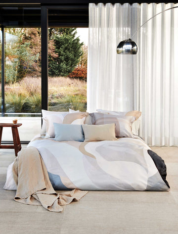 ELEMENTS dekbedovertrekset | multi Een bed in een rustige omgeving met dekbedovertrekken in pastelachtige kleuren beige en blauwe kleuren