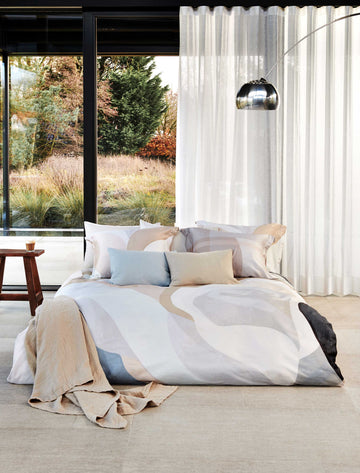 LUSH LAGOON XL dekbedovertrekset | linen Lush Lagoon linen dekbedovertrek heeft geometische vormen, waarbij strepen, rechthoeken en bogen in verschillende tinten paars, roze, oranje/beige door elkaar heen lopen. De achterkant van het dekbedovertrek is effen beige. De kussens hebben aan beide zijden een paar kleurvlakken.