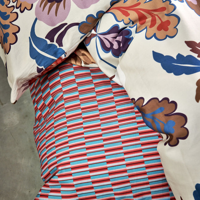 GRAPHIC dekbedovertrekset | multi detail shot van een dekbedovertrek met een grafische print in rode en blauwe kleuren en een dekbedovertrek met bloemen in blauw en rode kleuren