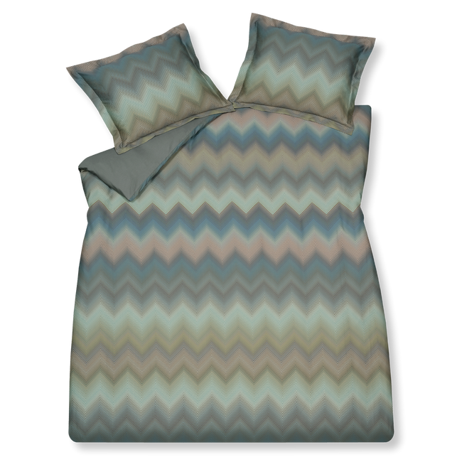 ZIGGY dekbedovertrekset | sage green Ziggy sage green dekbedovertrek heeft zigzag lijnen in verschillende tinten, groen blauw en rood. Als je er wat langer naar kijkt, dan lijken de lijnen wazig terwijl het strakgetrokken lijnen zijn. De achterkant van het dekbedovertrek is effen.