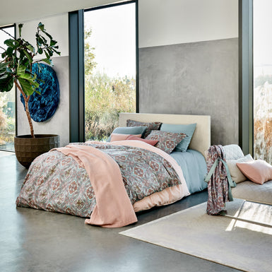 CHARM dekbedovertrekset | pearl blue een bed in een rustige setting in blauwe en roze tinten