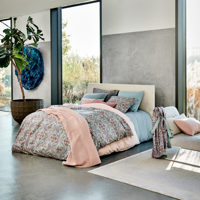 CHARM dekbedovertrekset | pearl blue een bed in een rustige setting in blauwe en roze tinten