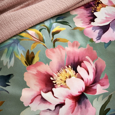 PINK PEONY dekbedovertrekset | multi detail shot van een dekbedovertrek met roze bloemen op een groene achtergrond en een plaid in een blush kleur