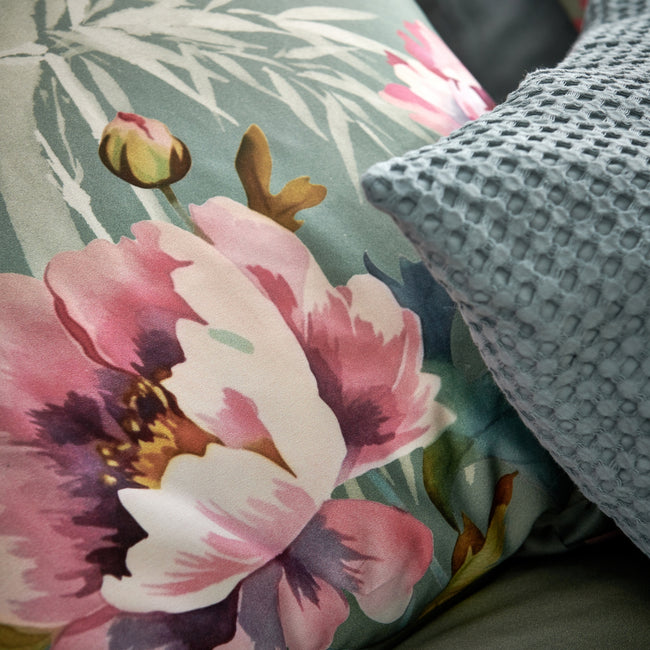 PINK PEONY dekbedovertrekset | multi detail shot van een kussen met roze bloemen en bamboe takken op een groene achtergrond