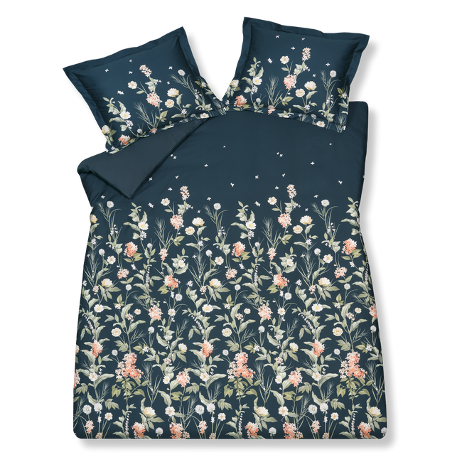 DARK MIDNIGHT dekbedovertrekset | blue ink Dark Midnight blue ink dekbedovertrek heeft licht oranje en witte bloemen op een donkerblauwe achtergrond. De achterkant van het dekbedovertrek is effen donkerblauw. De kussens hebben aan beide zijden verschillende bloemen aan de onderkant met hier en daar kleine blaadjes die lijken te dwarrelen.