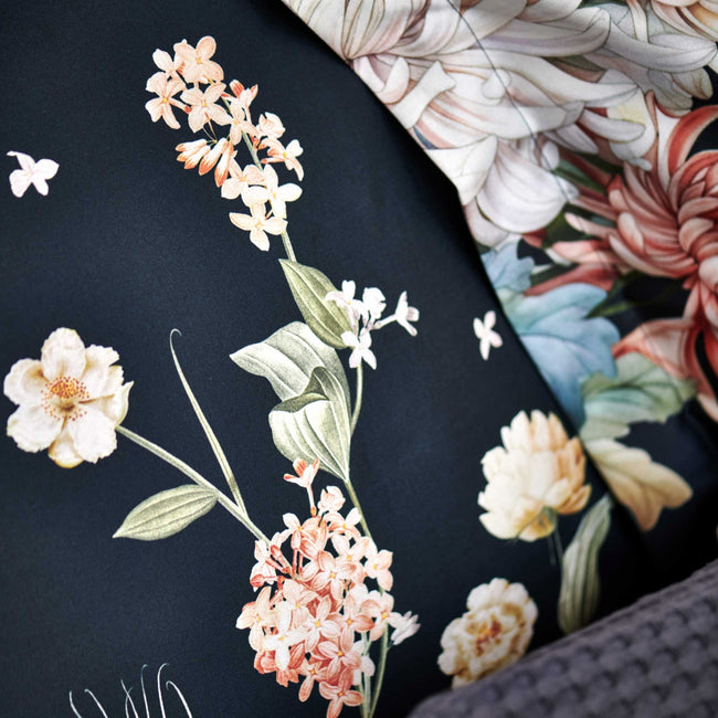 DARK MIDNIGHT dekbedovertrekset | blue ink detail shot van een hoofdkussen in een donkerblauwe kleur met oranje en roze bloemen