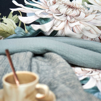 FLORAL BLISS dekbedovertrekset | blue ink detail shot van een dekbedovertrek in donkerblauw met witte bloemen en een sprei in een blauwe kleur