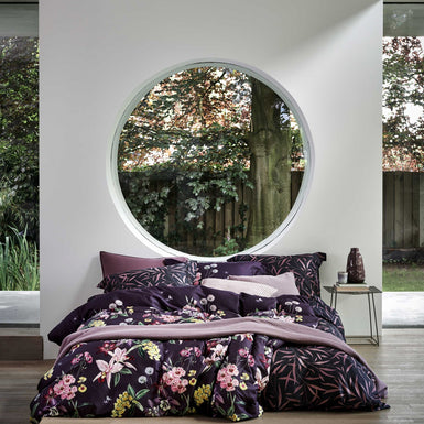 MOONLIT dekbedovertrekset | multi Een bed met een dekbedovertrek met bloemen en bladeren in paarse kleuren