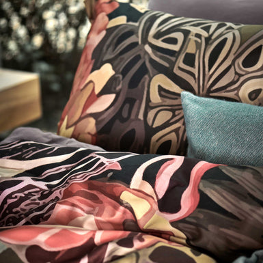 WILDSCAPE dekbedovertrekset | multi detail shot van een dekbedovertrek met een getekende print van bloemen en bladeren in paarse, roze en oranje kleuren