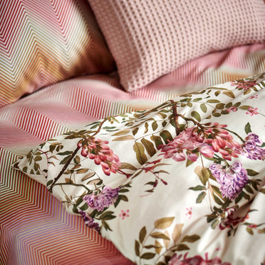 ROSE ACACIA dekbedovertrekset | cream tan detail shot van een dekbedovertrek met roze en paarse bloemen en een dekbedovertrek met zigzag print in roze en oranje kleuren