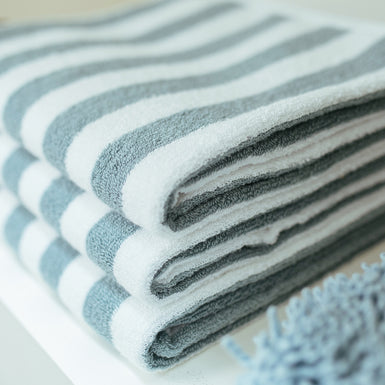een detail shot van opgevouwen handdoeken met een streepprint met een pearl blue kleur