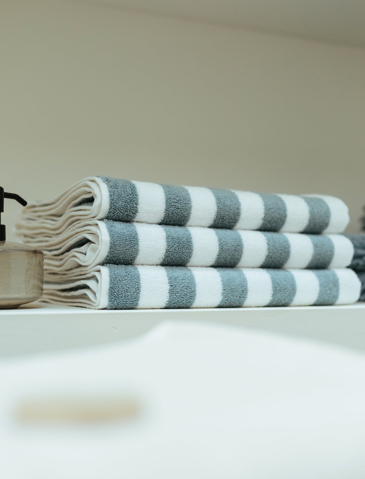 een detail shot van opgevouwen handdoeken met een streep print in wit en blauw
