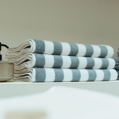 een detail shot van opgevouwen handdoeken met een streep print in wit en blauw