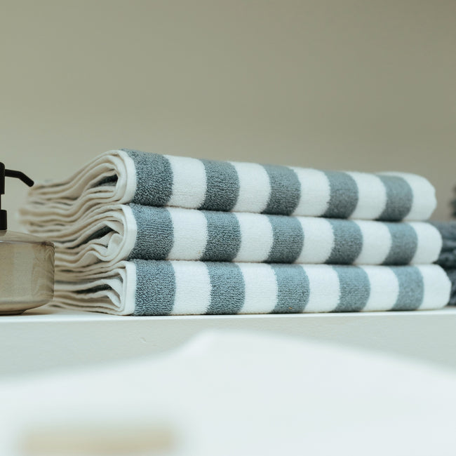 een detail shot van opgevouwen handdoeken met een streep print in wit en blauw