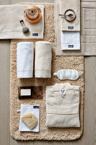 HOME MOULINE badgoed | bleached sand top shot van handdoeken, een badmat, badjas en badkamer accessoires in wit en zand tinten