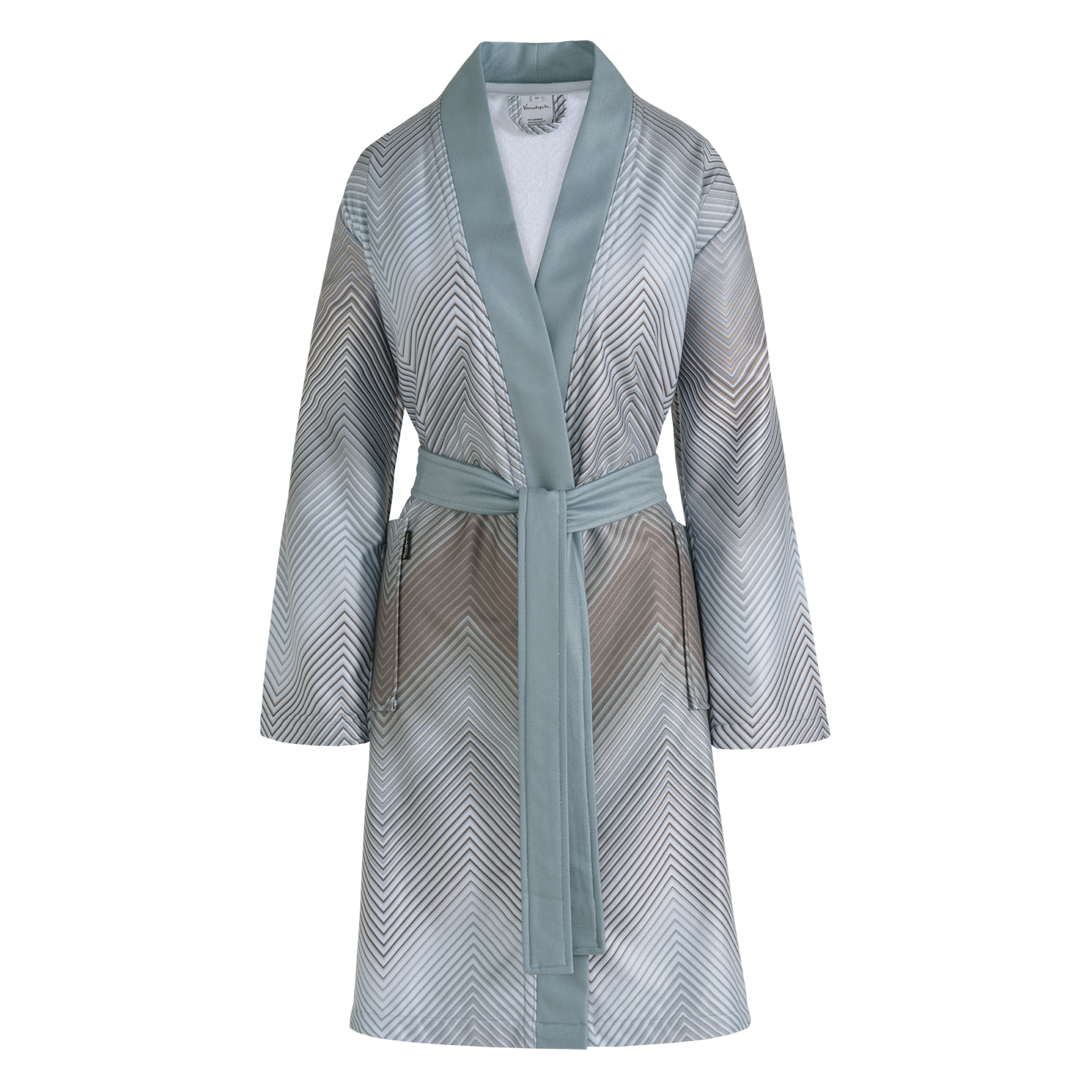 Bella badjas mineral blue is een lange badjas met hele fijne zigzaglijnen in blauw, grijs, bruin, wit en beige. De badjas heeft grote insteekzakken, brede blauwe groene revers en wordt gesloten met een ceintuur. De Bella badjas mineral blue van Vandyck heeft door de fijne lijnen en lichte kleuren een subtiele elegantie. 