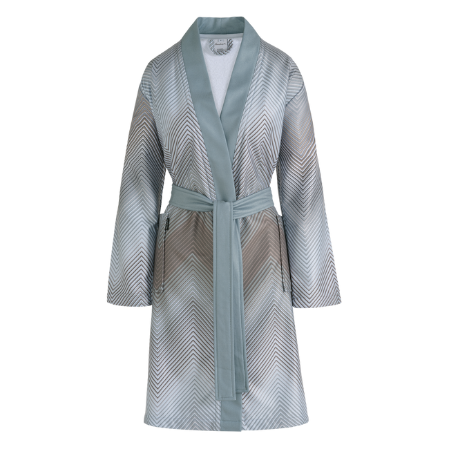 Bella badjas mineral blue is een lange badjas met hele fijne zigzaglijnen in blauw, grijs, bruin, wit en beige. De badjas heeft grote insteekzakken, brede blauwe groene revers en wordt gesloten met een ceintuur. De Bella badjas mineral blue van Vandyck heeft door de fijne lijnen en lichte kleuren een subtiele elegantie. 