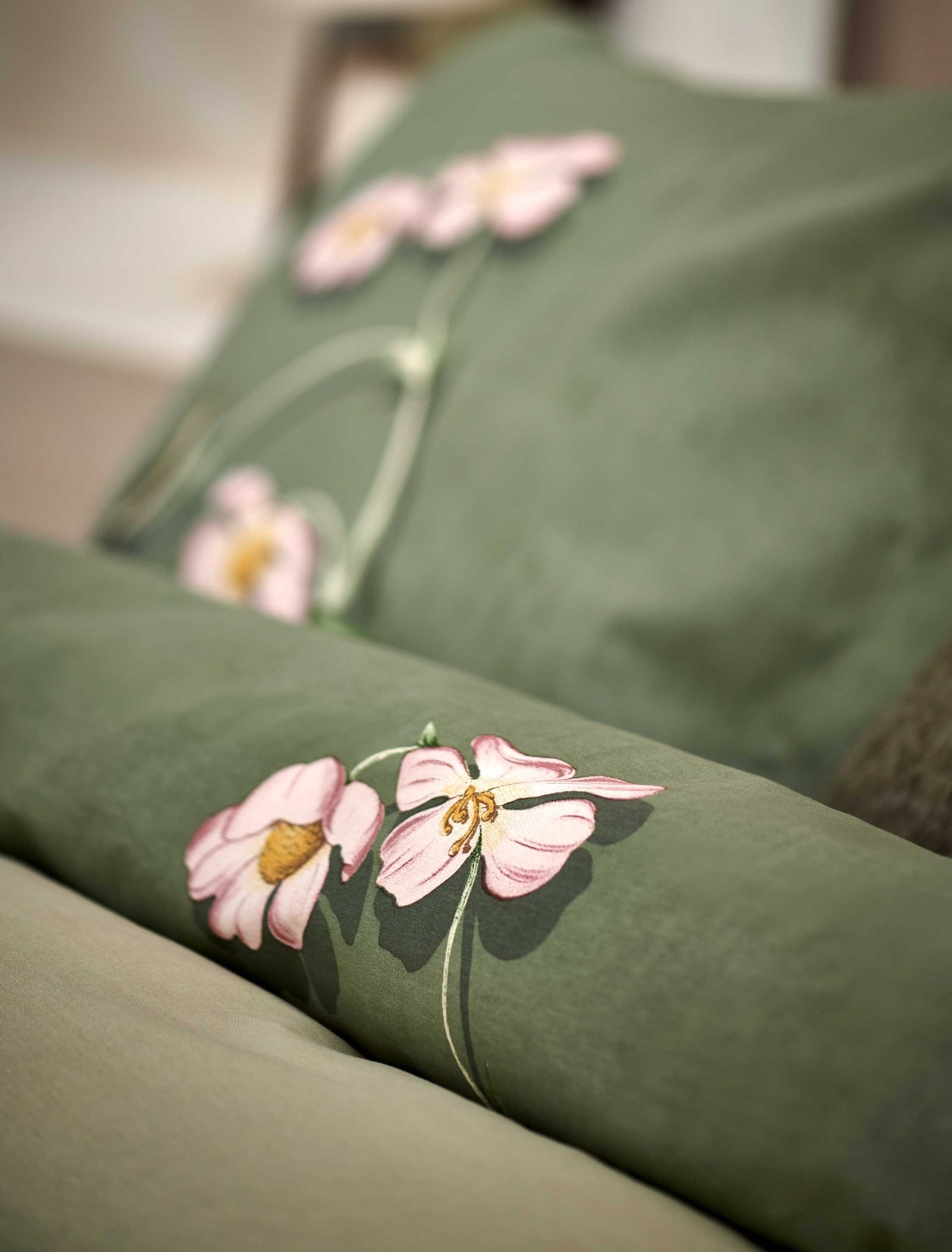 detail shot van een dekbedovertrek in een groene kleur met roze bloemen