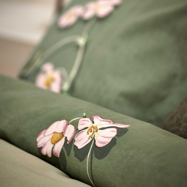 detail shot van een dekbedovertrek in een groene kleur met roze bloemen