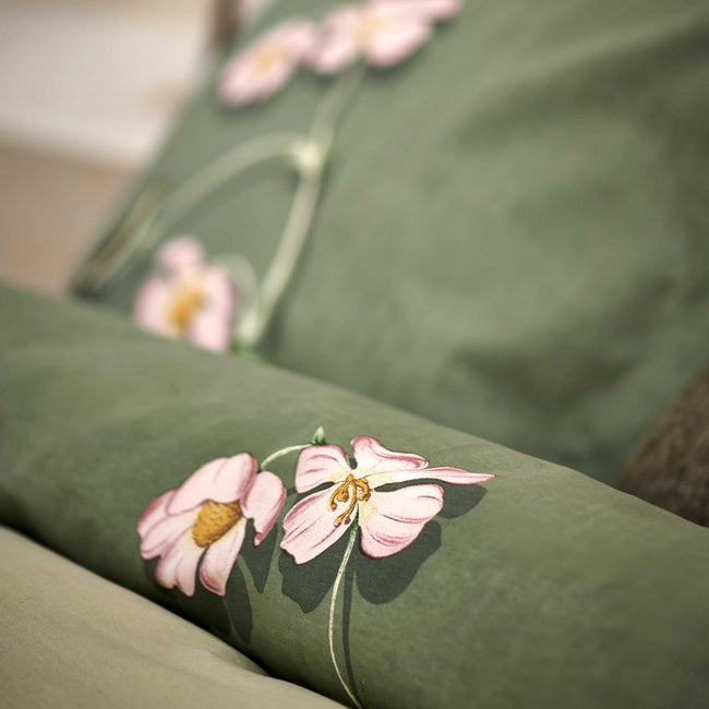 detail shot van een dekbedovertrek in een groene kleur met roze bloemen