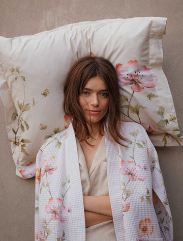 AMY badjas | cream tan Amy multi badjas heeft roze en oranje bloemen aan takjes met groene blaadjes op een effen beige achtergrond.