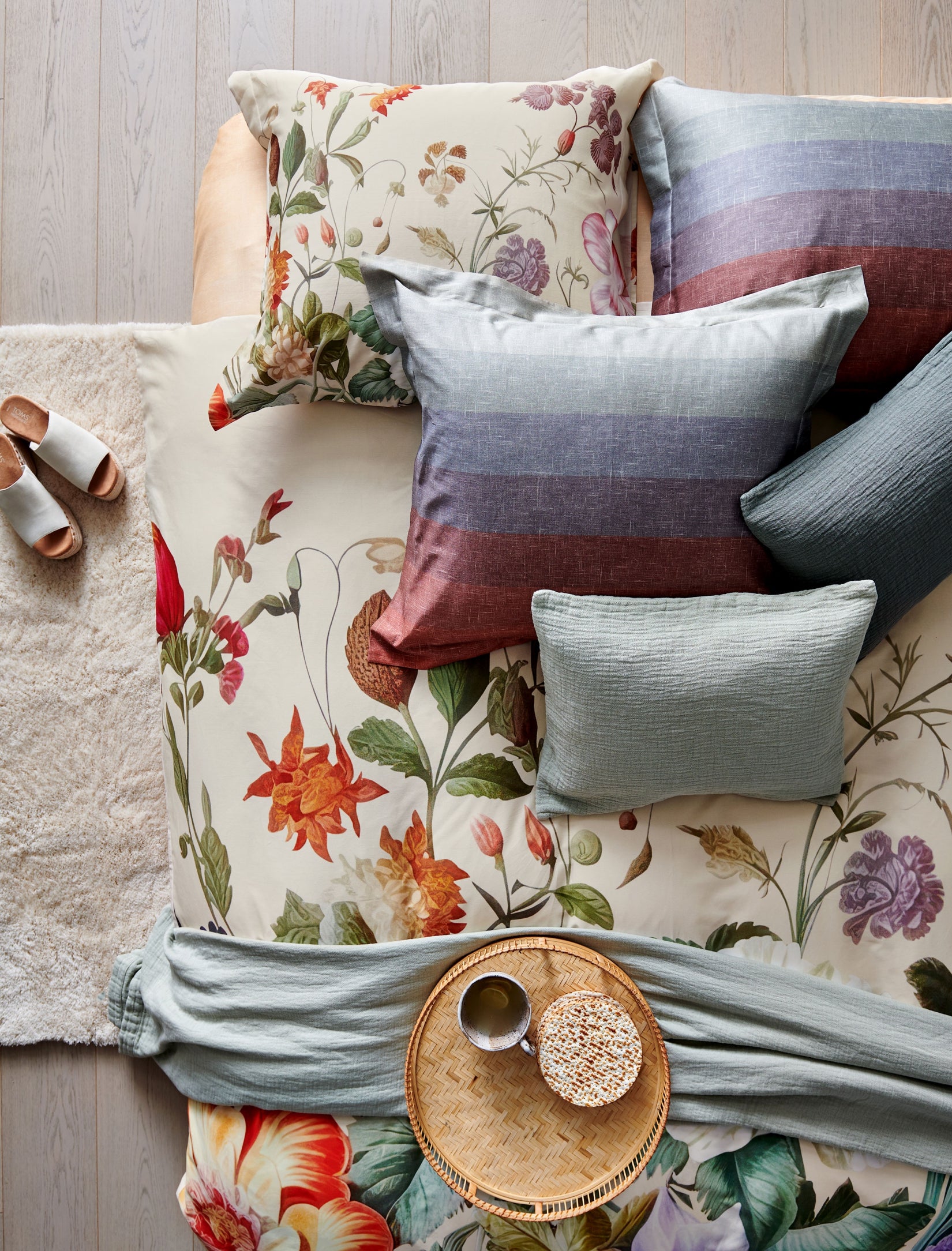 top shot van een dekbedovertrek in creme kleur met prachtige bloemen en een design met strepen in een mooie overloop van blauwe en rode kleuren