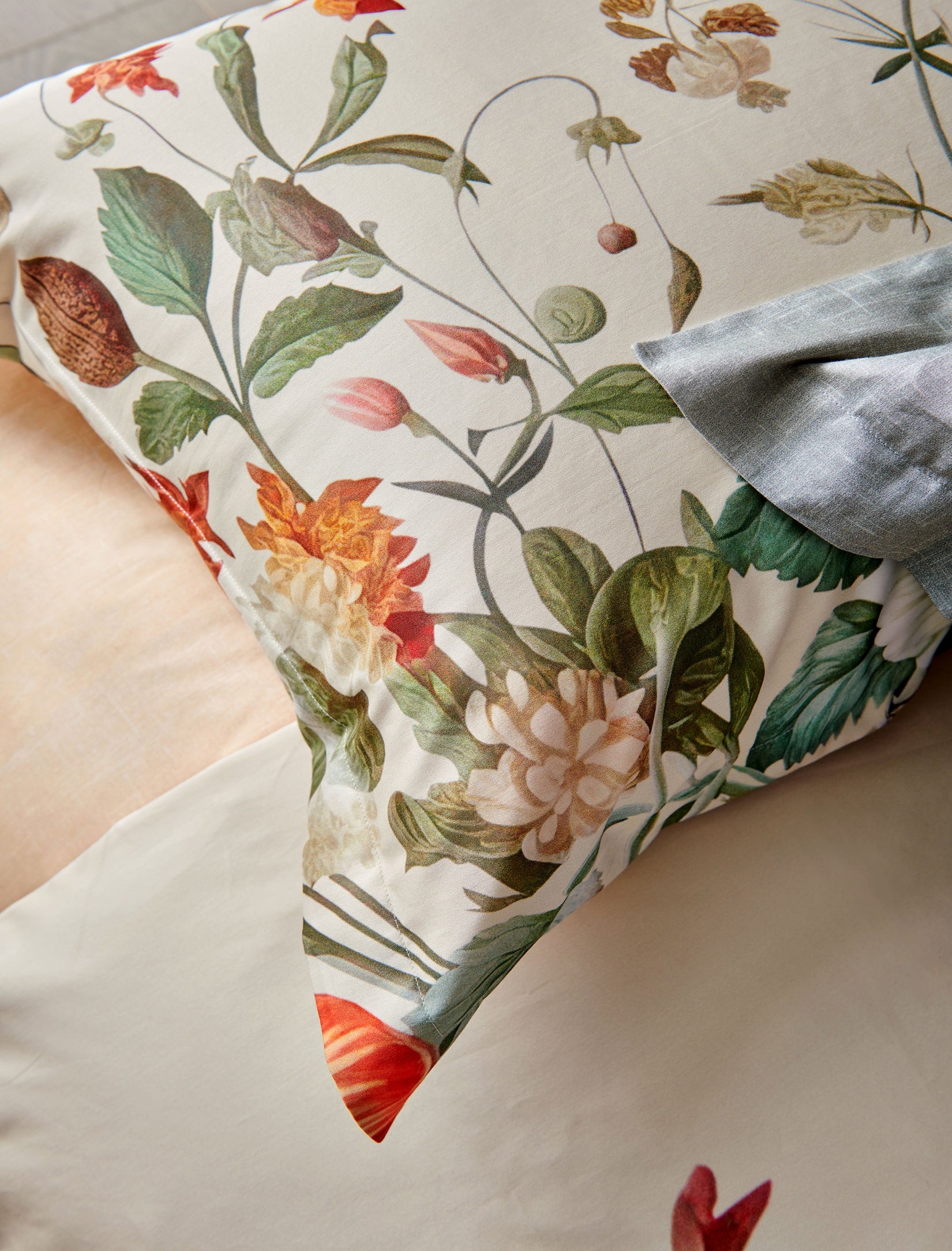 Detail shot van een kussensloop met prachtige bloemen en planten op een beige achtergrond