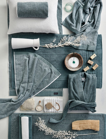 HOME PETIT LIGNE badgoed | pearl blue een top shot van handdoeken in blauwe en witte kleuren, een badjas en badkamer accessoires