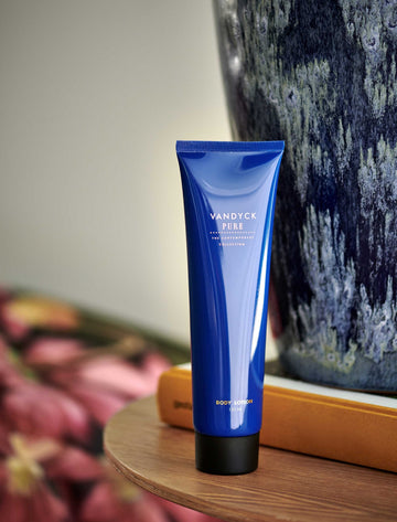 een body lotion in een blauwe tube met gouden letters
