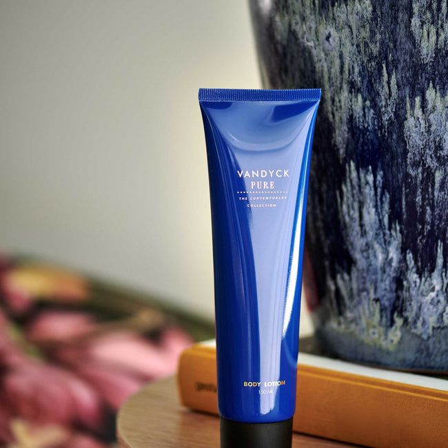 een body lotion in een blauwe tube met gouden letters