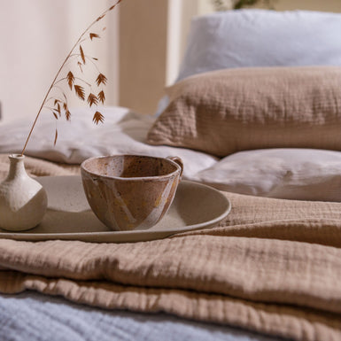 detail shot van een bed met een kopje thee in een rustige sfeer