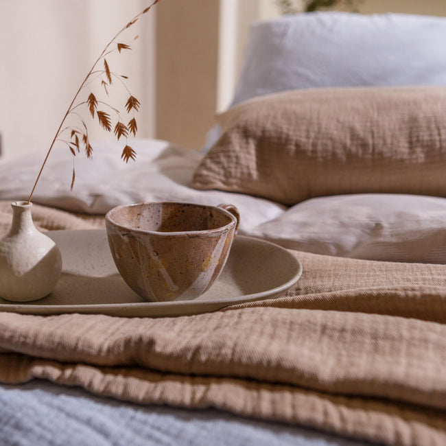 detail shot van een bed met een kopje thee in een rustige sfeer