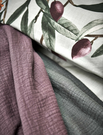 PURE 68 sprei | moonscape detail shot van een kussensloop met olijven print en een sprei in een paarse en groene kleur