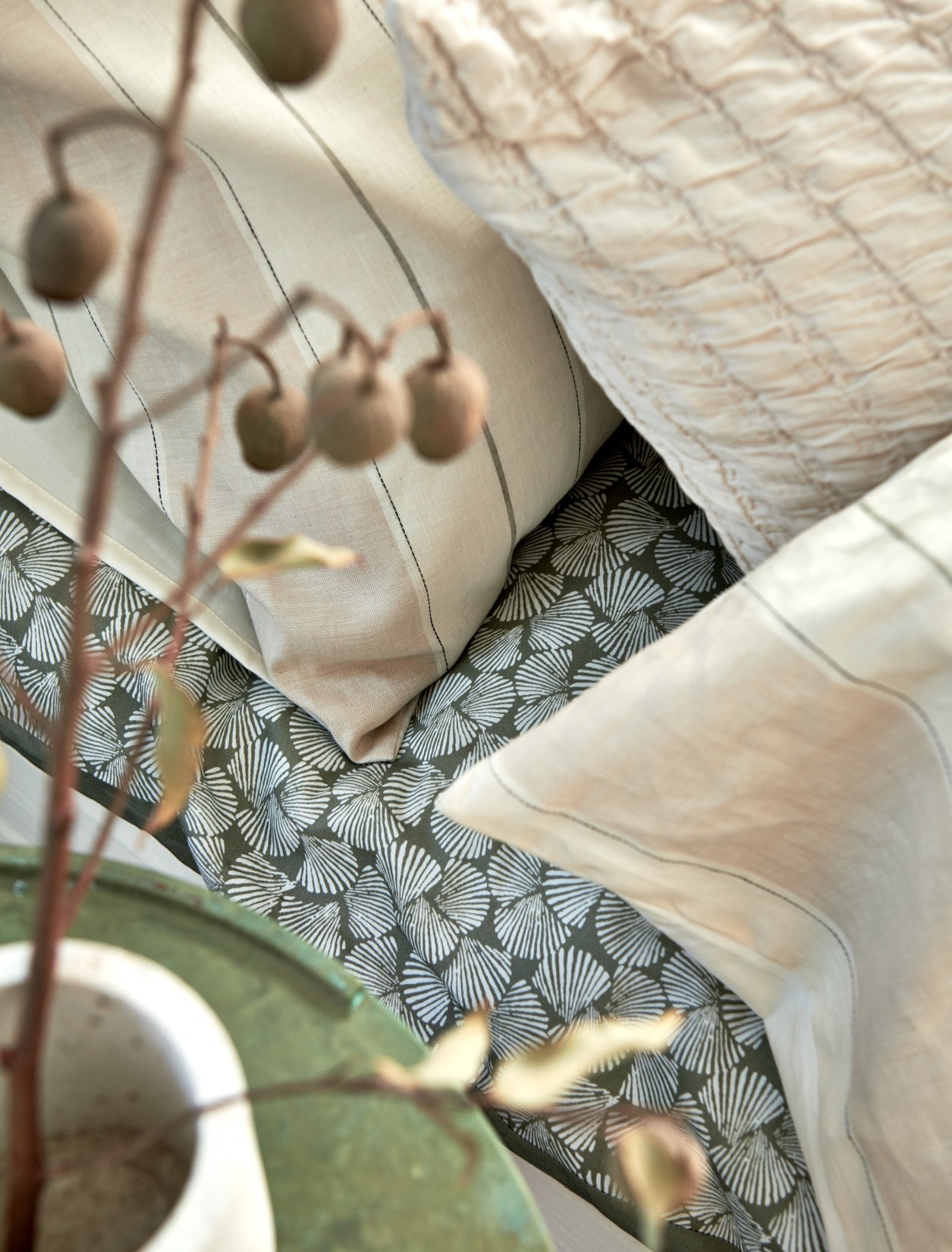 Detail shot van een bed in beige en groene tinten