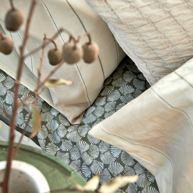 Detail shot van een bed in beige en groene tinten