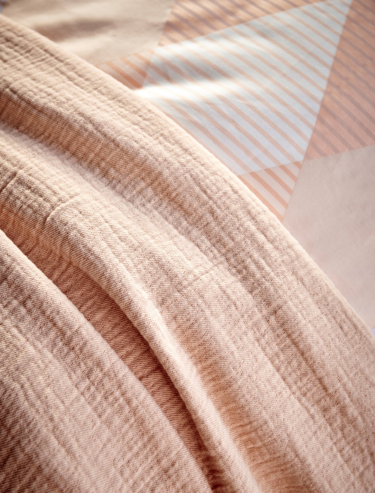 een sprei in een pastel oranje kleur